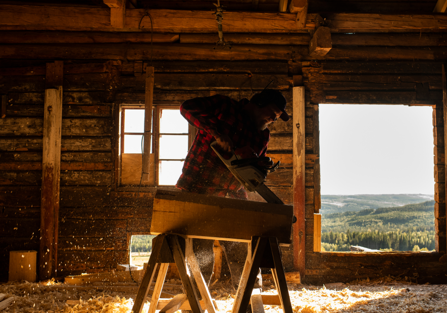 Craftsman working with wood inside a traditional wooden workshop